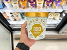 hang holding one pint of Halo Top ice cream in front of store freezer