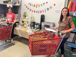 Two teachers pushing shopping carts in Schoolhouse Supplies.