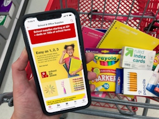 Target app on a cell phone with school supplies in a cart behind it.