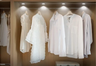 clothes hanging in lit closet