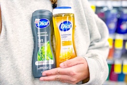 person holding 2 bottles of dial body wash in front of their body