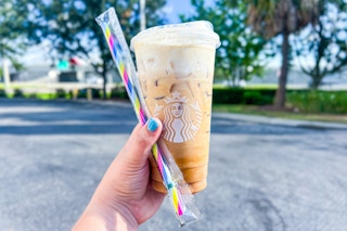 someone holding a starbucks drink and free reusable straws