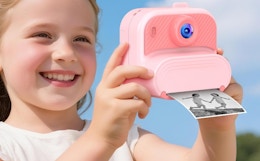 a little kid holding a pink camera