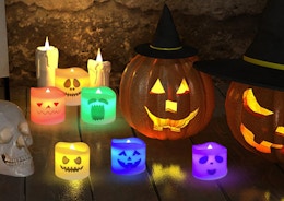 flameless Halloween candles next to pumpkins