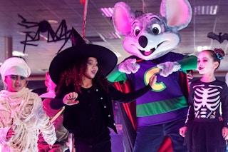 kids in a halloween costume dancing with chuck e cheese at the boo-tacular event 