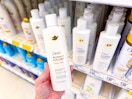 Person holding dove shampoo in aisle