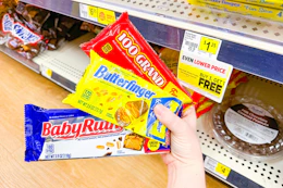 hand holding fun size packs of 100 grand, baby ruth, butterfinger