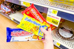 hand holding fun size packs of 100 grand, baby ruth, butterfinger