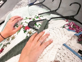 Some clothes being put on the counter at Plato's Closet