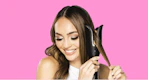 a woman holding a hair curler