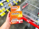 hand holding motrin next to cvs cart