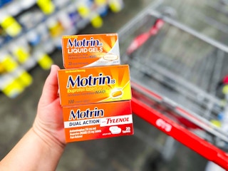 hand holding motrin next to cvs cart