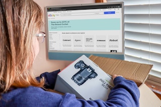 someone opening up a package from ebay with the ebay brand outlet on the computer