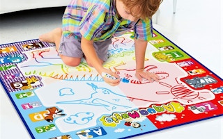 A small child coloring on a water doodle mat.