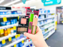 hand holding four maybelline cosmetics