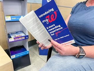 A person looking through a Walgreens MyW program book while shopping