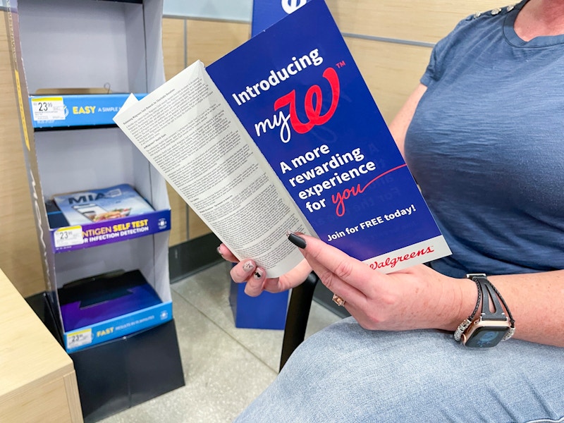 A person looking through a Walgreens MyW program book while shopping