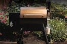 Traeger Grills Pro 22 Wood Pellet Grill & Smoker outside by shrubbery. 