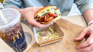 a person holding a mcdonalds mccrpisy sandwich