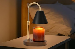 black and gold candle warmer lamp next to bed