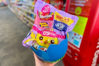 hand holding an easter basket with big bag of easter assorted candy in it