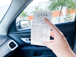 someone holding ulta receipt in car