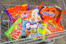 bags of candy in a cart including reese's, twix, trolli, kit kat, and snickers