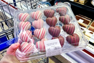 hand holding a pack of members mark heart shaped cake bites
