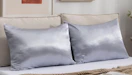 two satin pillows on a bed