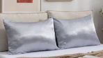 two satin pillows on a bed