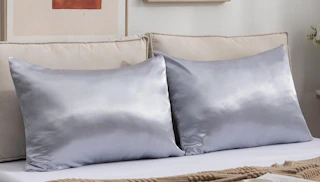 two satin pillows on a bed