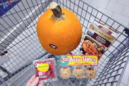 raspberries, caramel apples, schnitzel, and a pumpkin in a cart