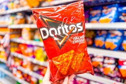 hand holding a bag of doritos