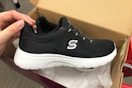 hand grabbing a skechers women's shoe out of a shoe box at target