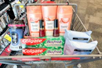 downy beads, suave shampoo, revlon nail polish, colgate toothpaste, and neutrogena wipes in a cart