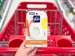 hand holding a glade small room air freshener in front of a target shelf