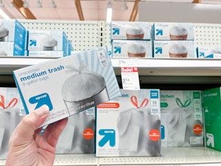 hand holding a box of up & up trash bags in front of a target shelf