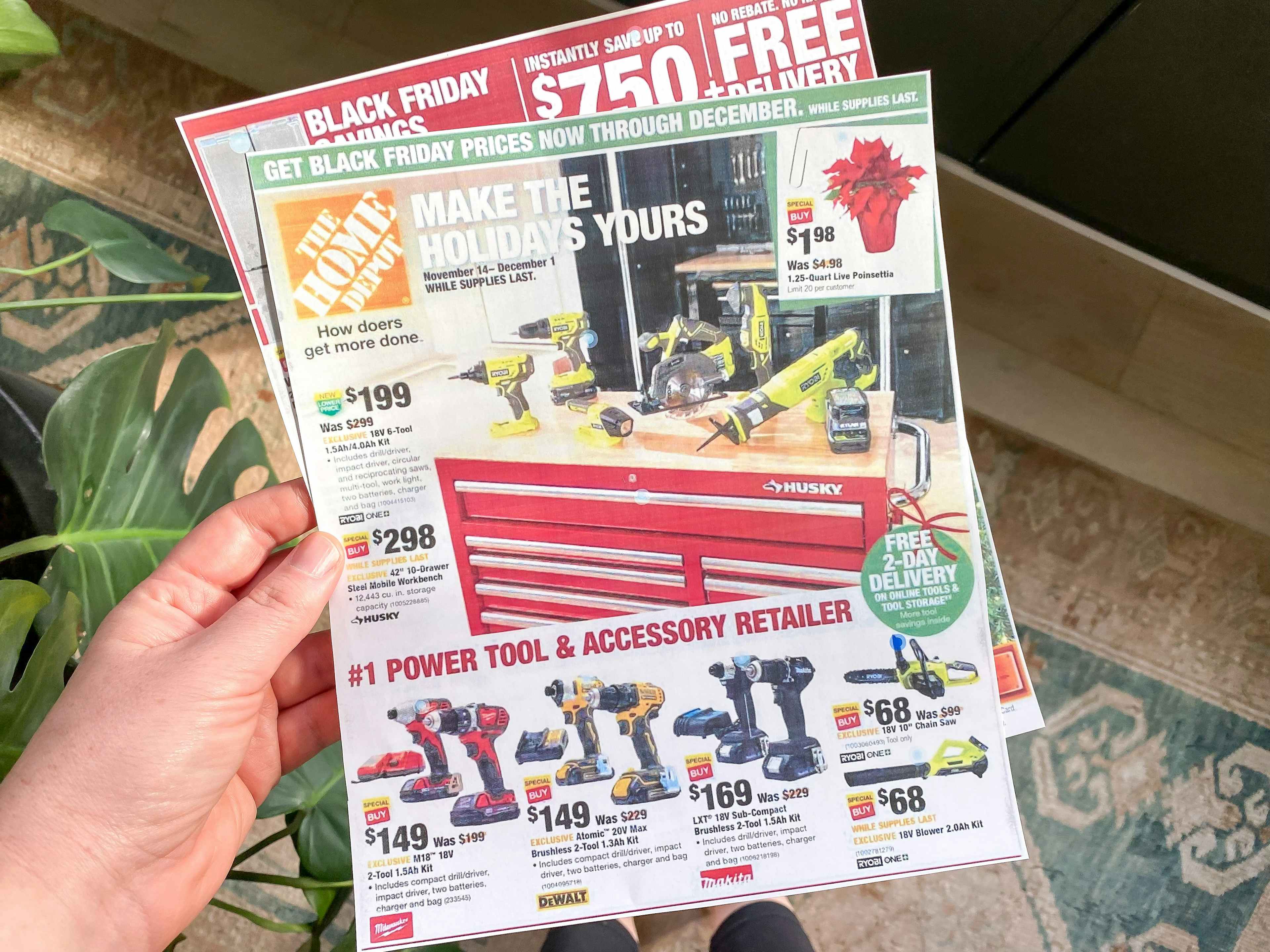 A person's hand holding a Home Depot Black Friday deals ad.