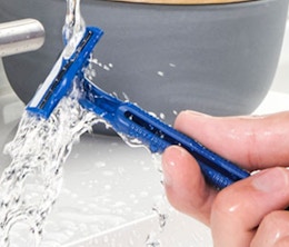 a hand holding a blue razor