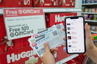Coupons and a cell phone next to huggies diapers and a Free Gift Card Sign