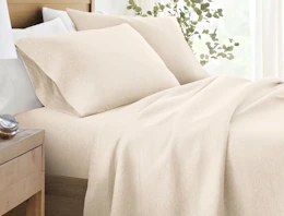 a beige jersey knit sheet set on a bed
