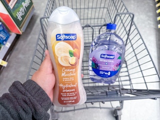 hand holding softsoap body wash and hand soap refill in walgreens cart