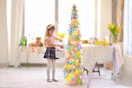 Lifestyle image of 5-foot Easter tree being decorated by a child