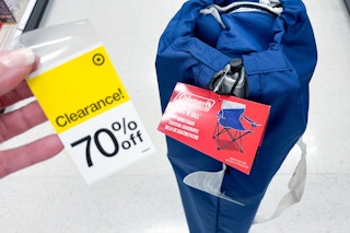 hand holding a clearance sticker in front of a coleman quad chair at target