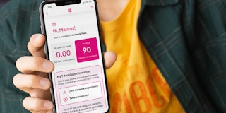 Mockup of a man holding an iPhone with the T-Mobile free trial dashboard on screen.