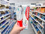 hand holding colgate oral care products in walgreens
