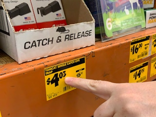 A hand pointing at a price tag ending in three