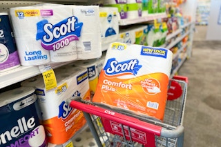 pack of toilet paper in cvs shopping cart next to shelf in household paper products aisle