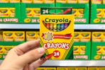 hand holding a box of crayola crayons