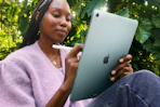 Woman sitting outside using the Apple iPad Air 11-inch with M3.
